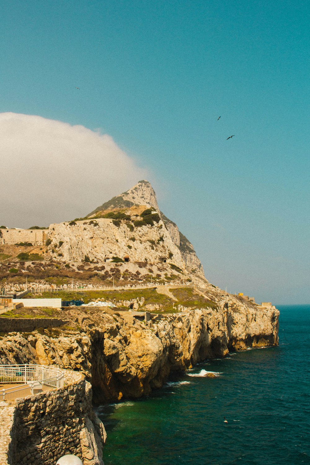 a rocky cliff overlooks a body of water