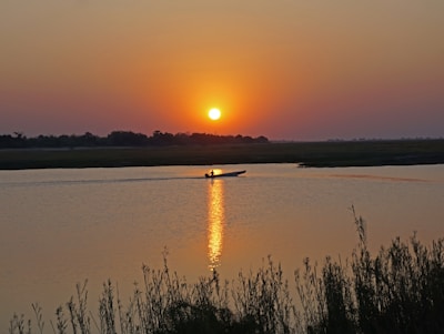 the sun is setting over a body of water