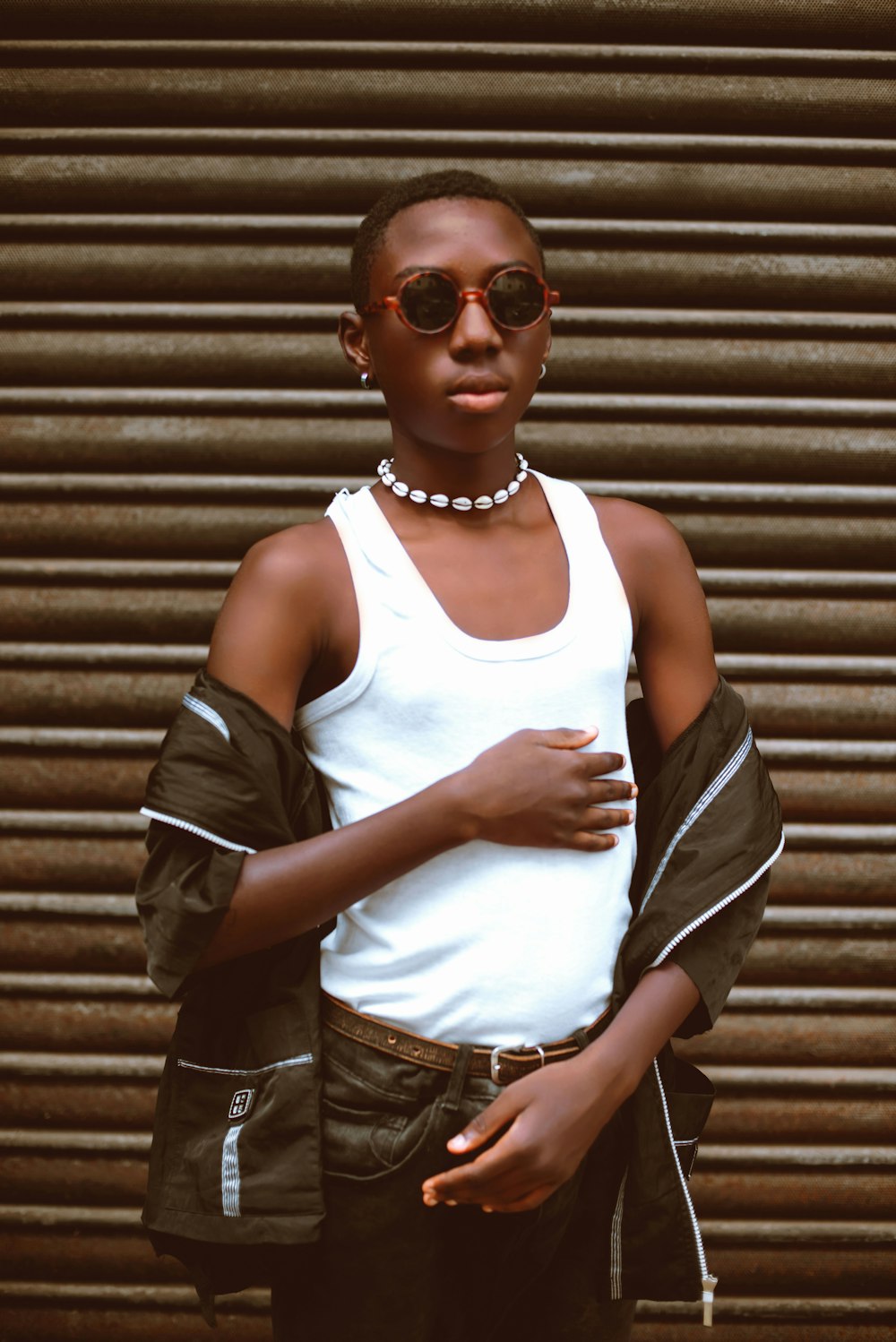 a woman wearing sunglasses and a white tank top