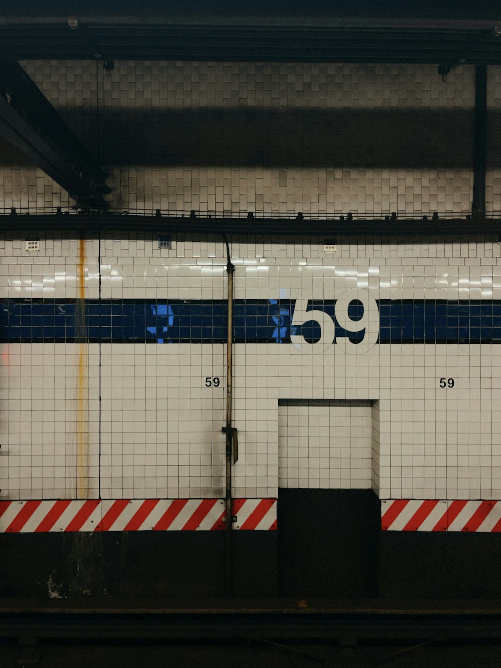 a subway station with a sign on the wall