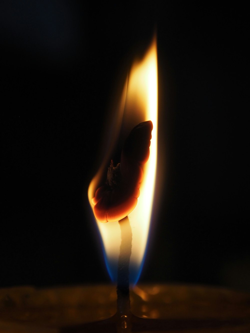 a close up of a lit candle with a dark background