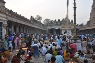 A serene temple courtyard in Sri Lanka with devotees lighting oil lamps.