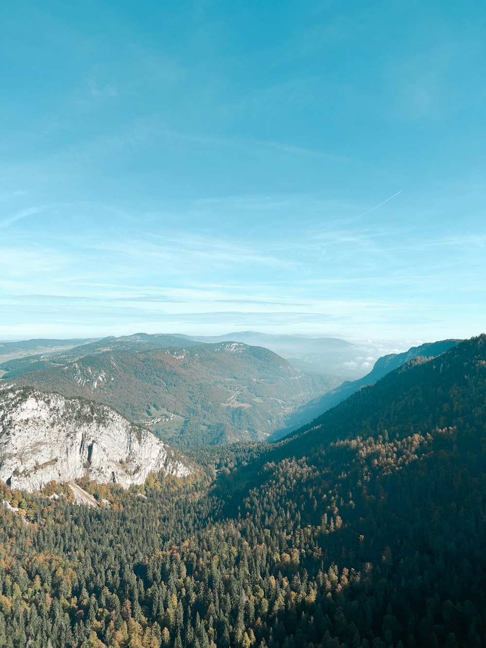 a view of a mountain range with trees in the foreground