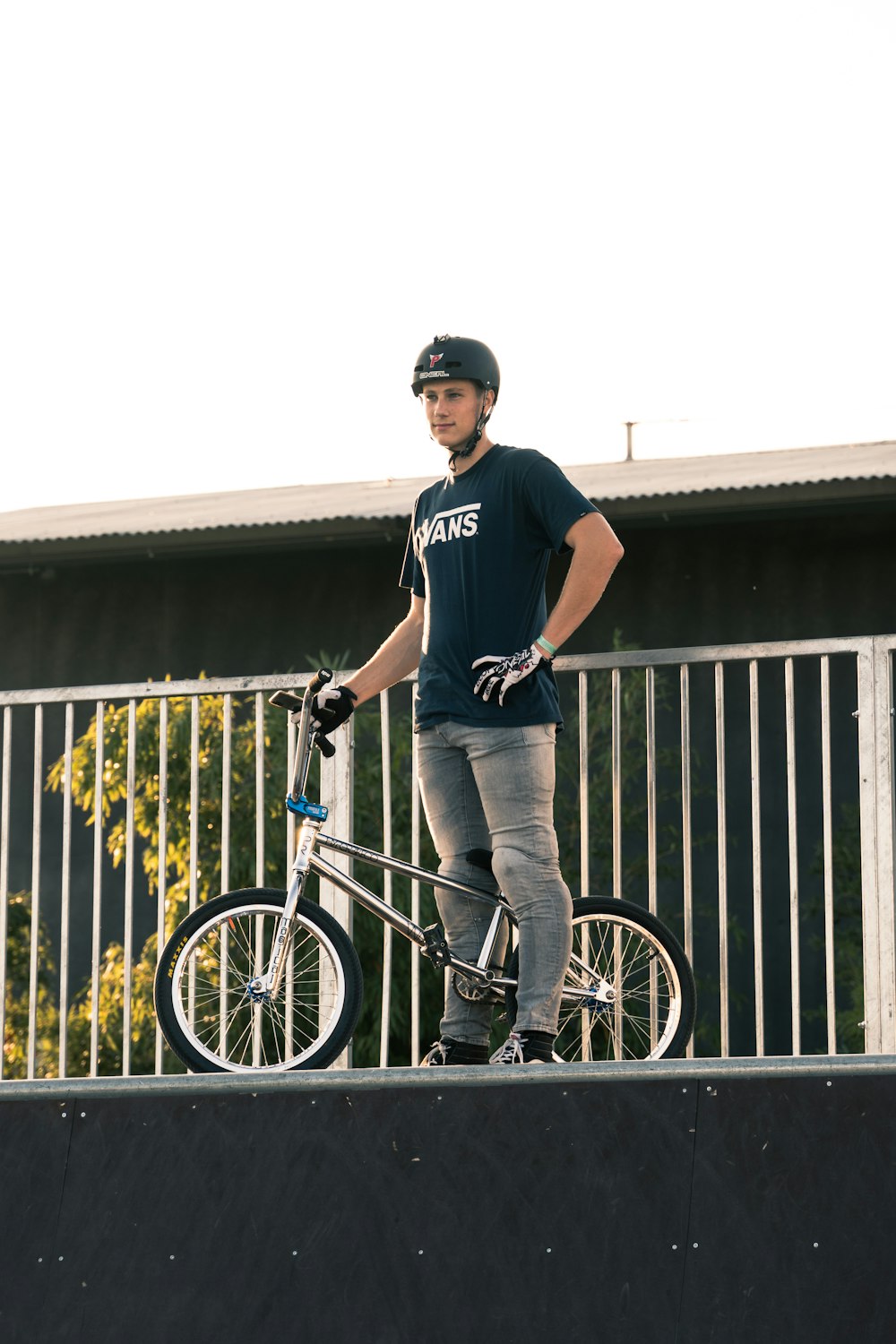 a man standing next to a bike on a ramp