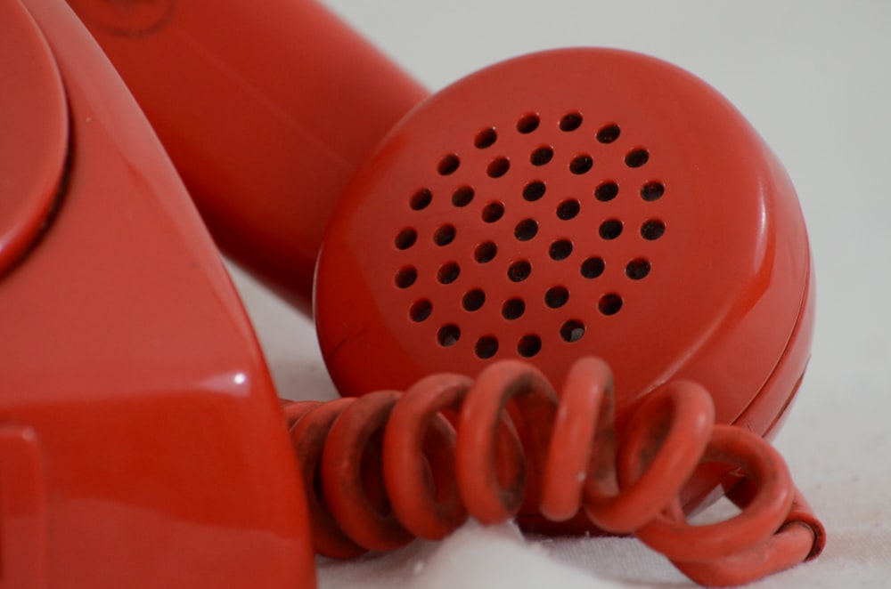 a red telephone sitting on top of a white table