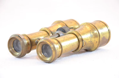 A close-up of a vintage brass spyglass resting on a wooden table, softly lit to evoke curiosity and craftsmanship.