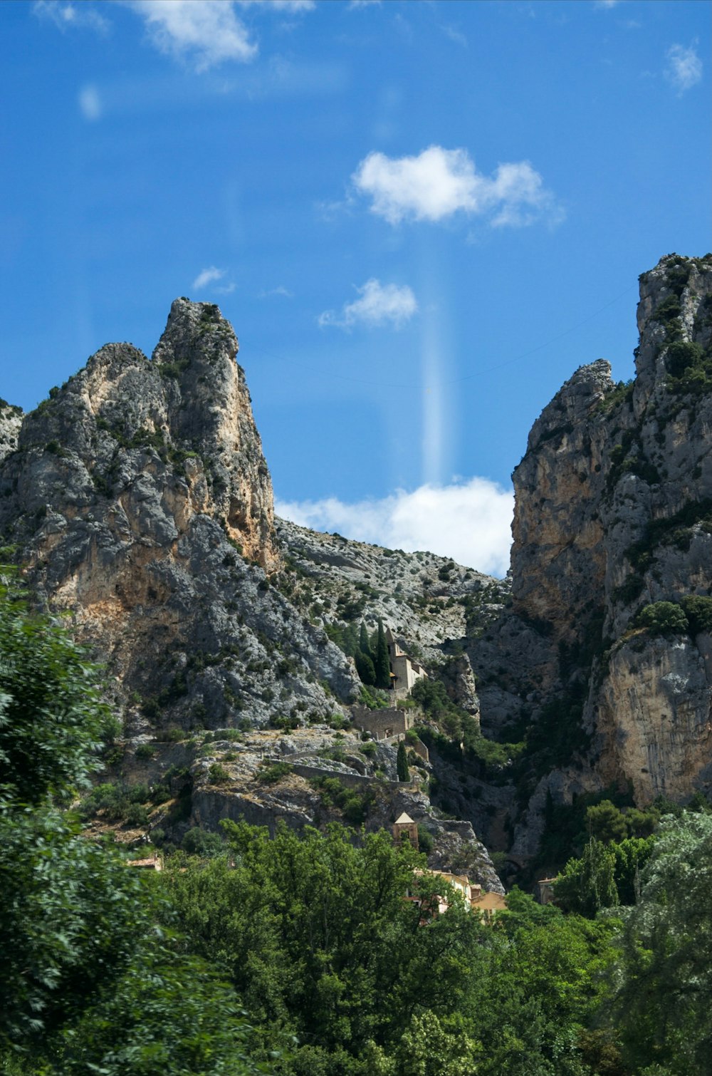 uma vista de uma montanha rochosa com um fundo do céu
