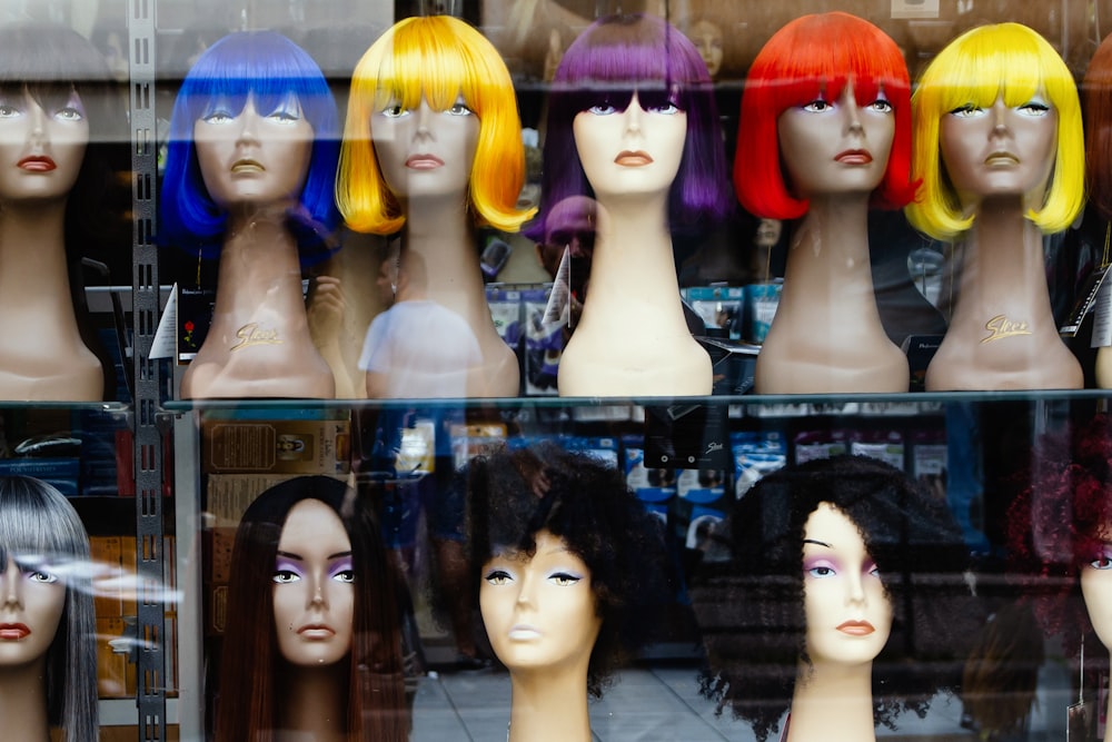 a bunch of wigs that are on display