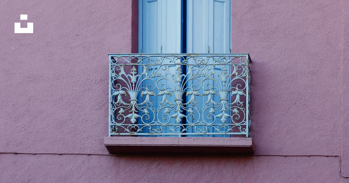 A pink building with two balconies and a blue door photo – Free ...