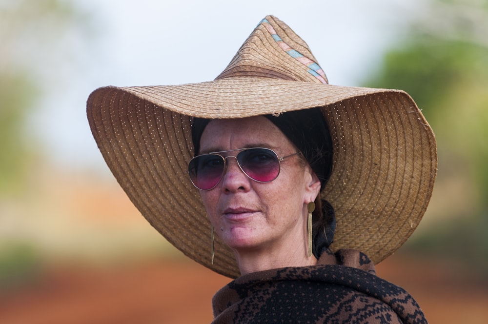 a woman wearing a straw hat and sunglasses