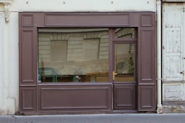 a store front with a window that has a reflection of a car in the window