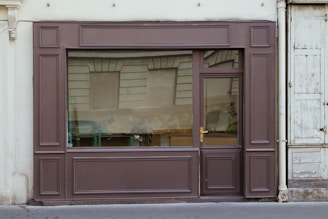 a store front with a window that has a reflection of a car in the window