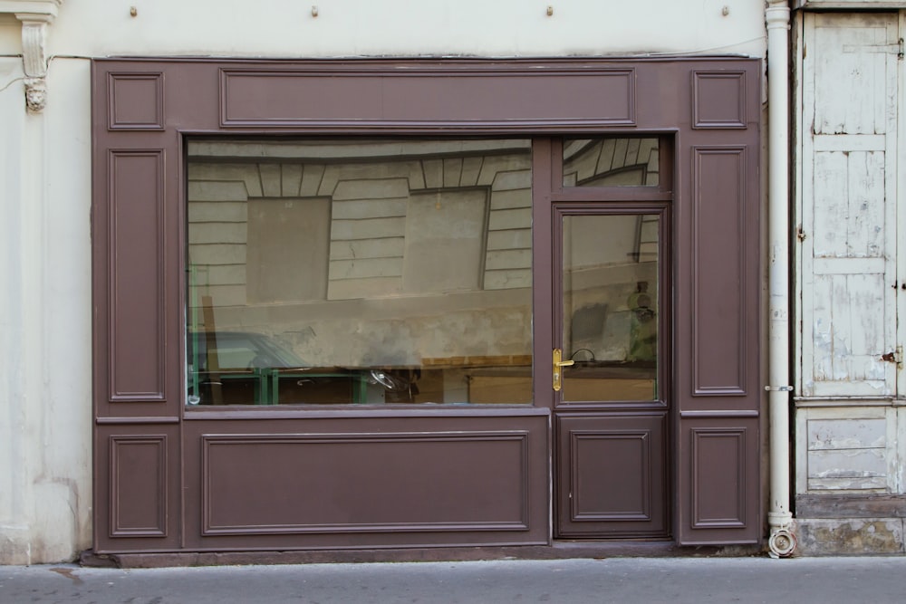 Un frente de tienda con una ventana que tiene un reflejo de un automóvil en la ventana