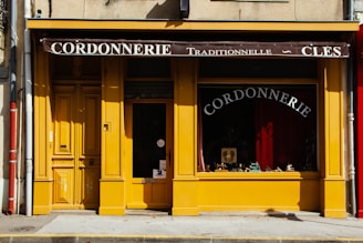 a yellow storefront with a red awning
