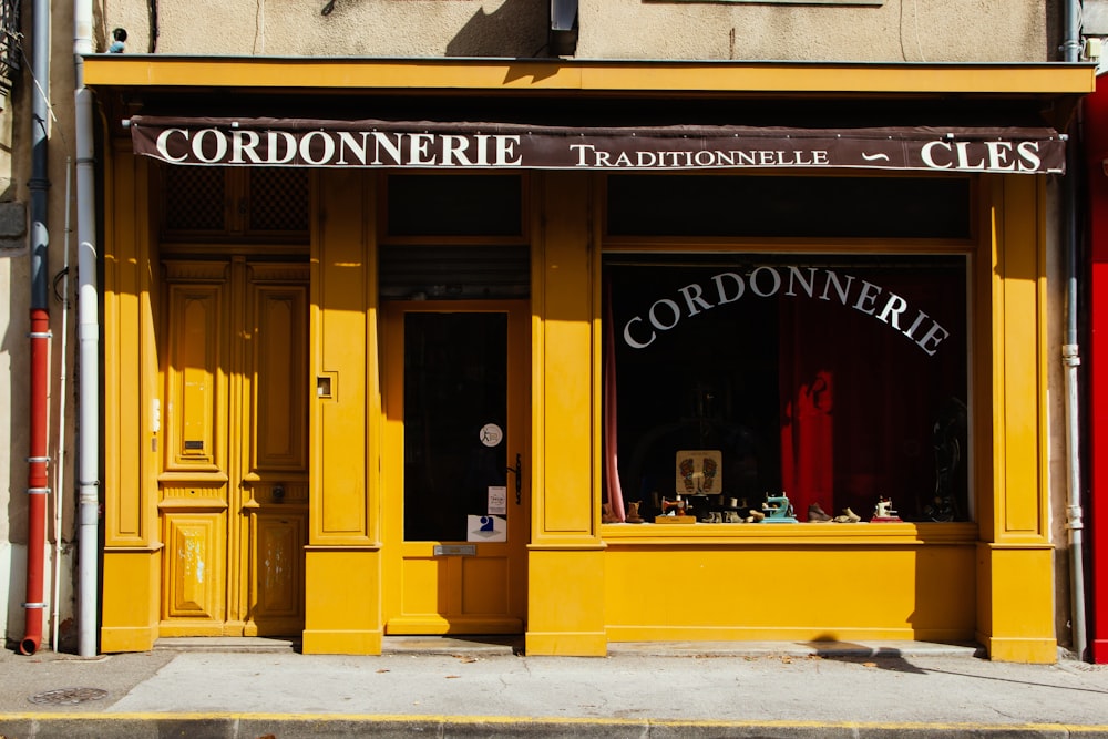 a yellow storefront with a red awning