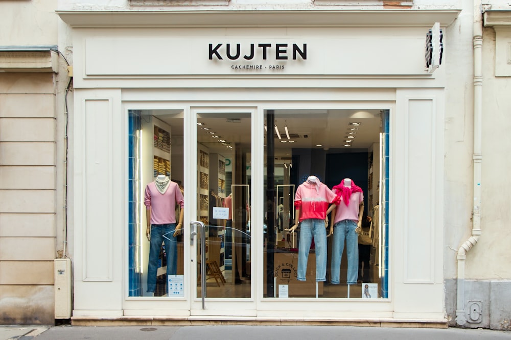 a store front with mannequins dressed in pink and blue