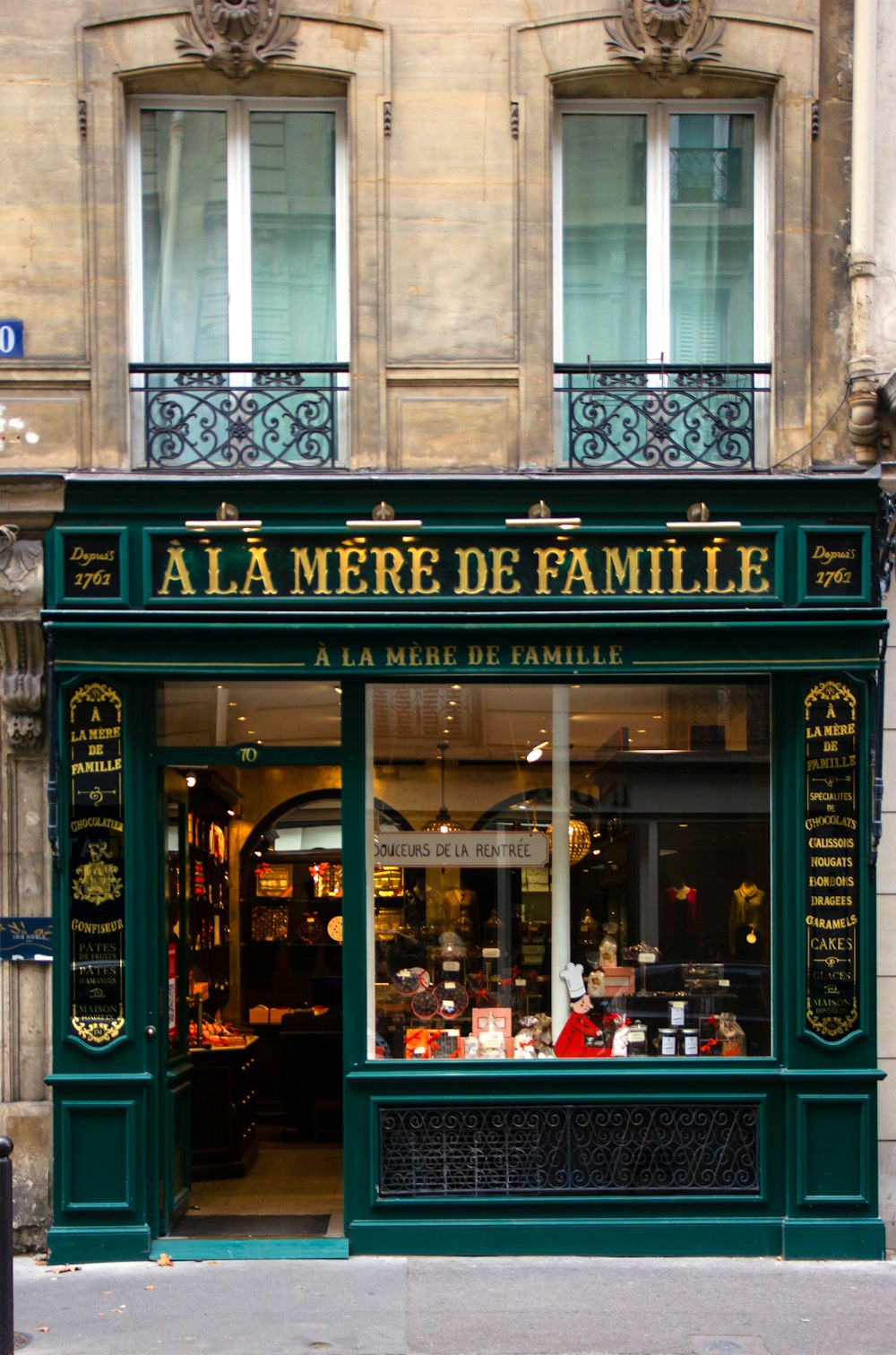 une devanture de magasin avec un auvent vert dans une rue de la ville