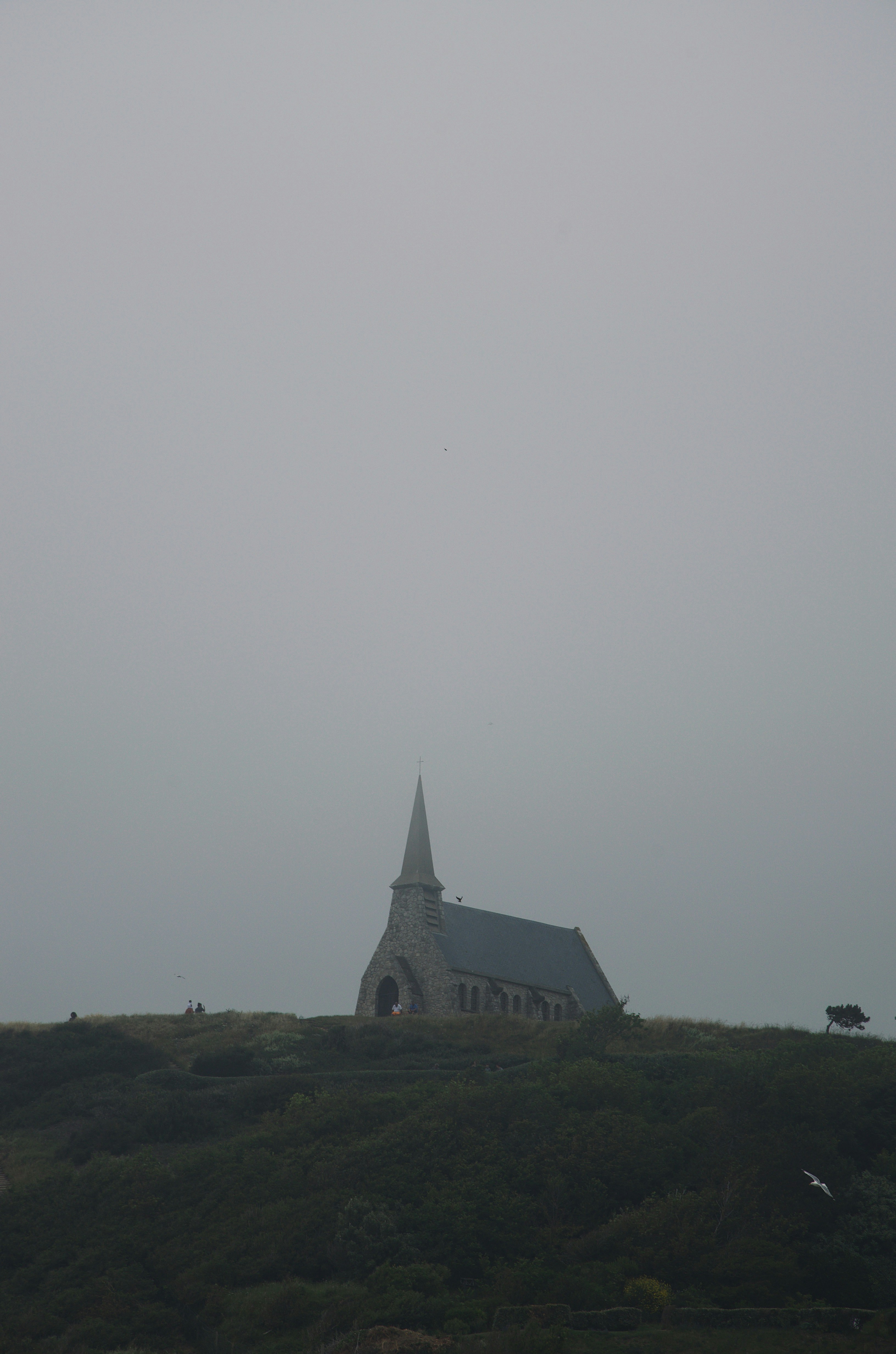 Una iglesia en la cima de una colina en un día de niebla