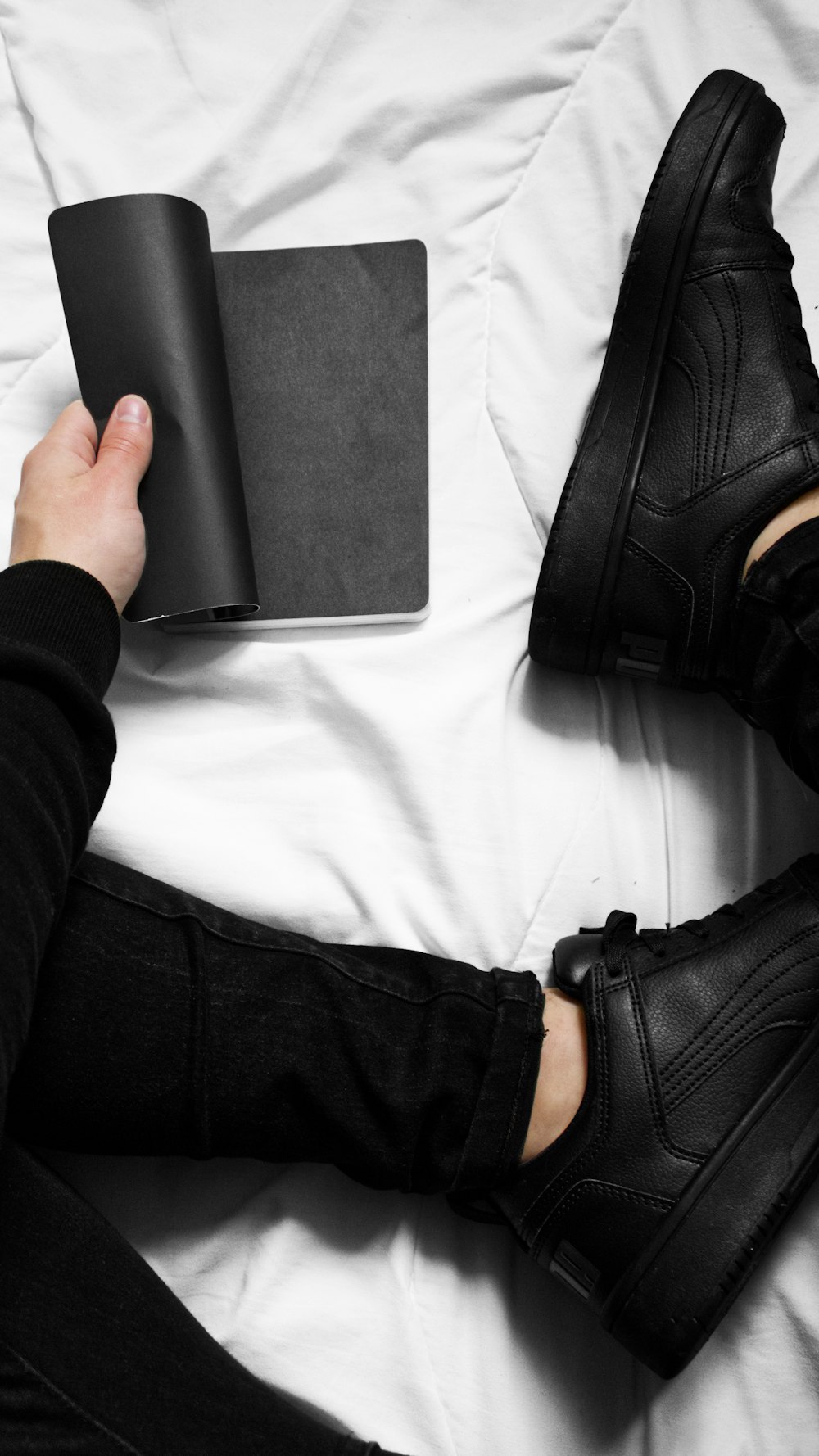 a person sitting on a bed holding a book