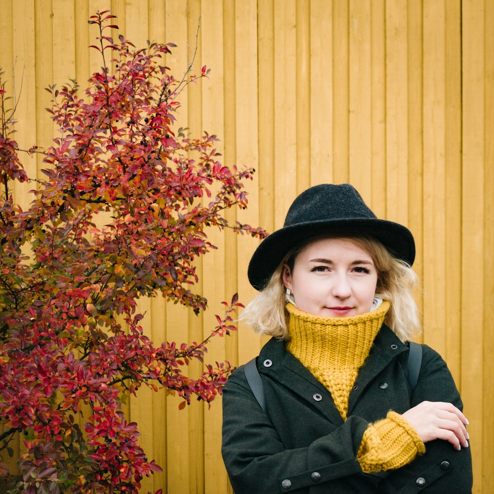 a woman wearing a black hat and a yellow scarf