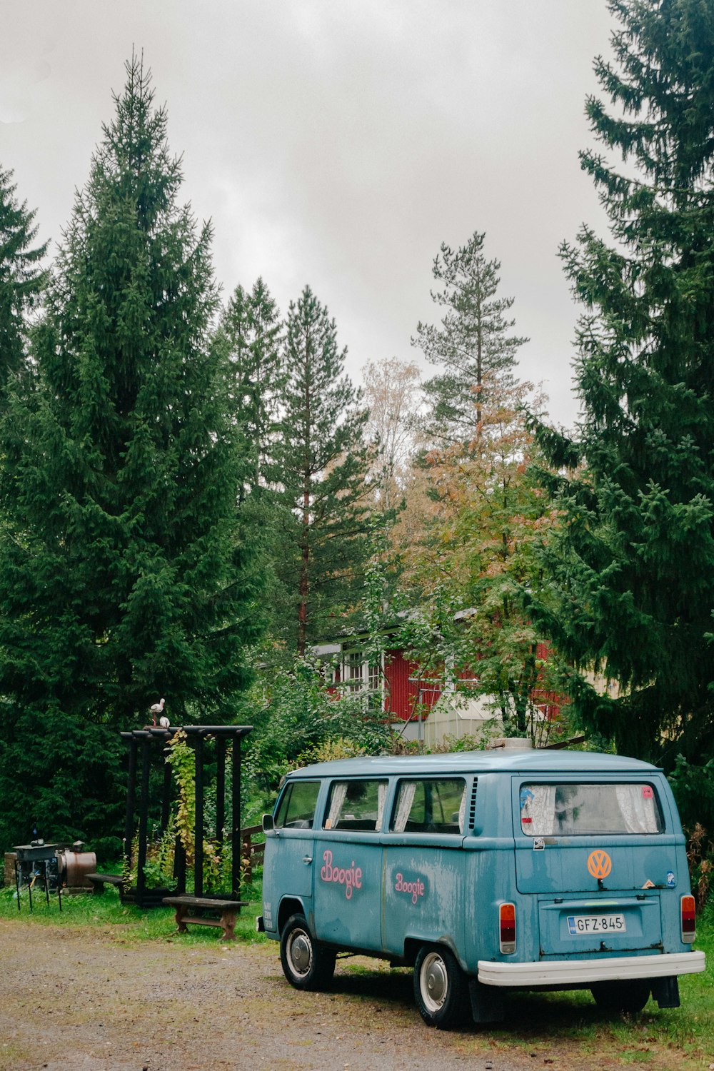 a blue van parked in front of a forest