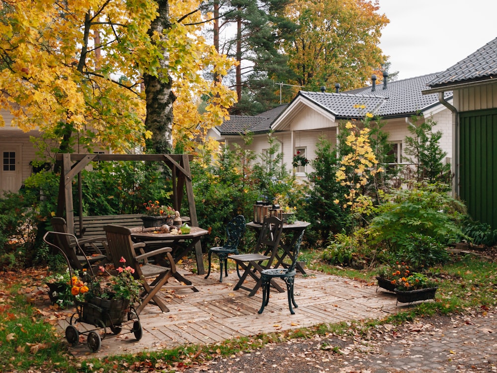 a patio with a table, chairs and a bench