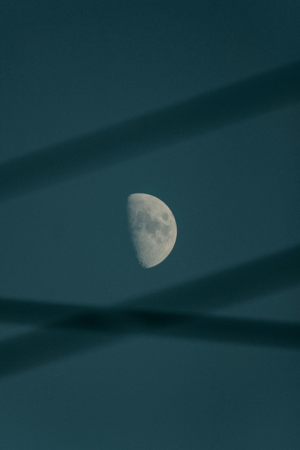 the moon is seen through the thin lines in the sky