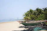 a boat sitting on top of a sandy beach