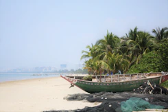 a boat sitting on top of a sandy beach