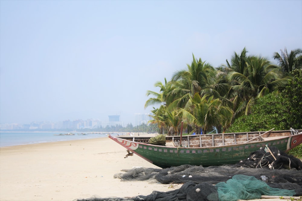 a boat sitting on top of a sandy beach