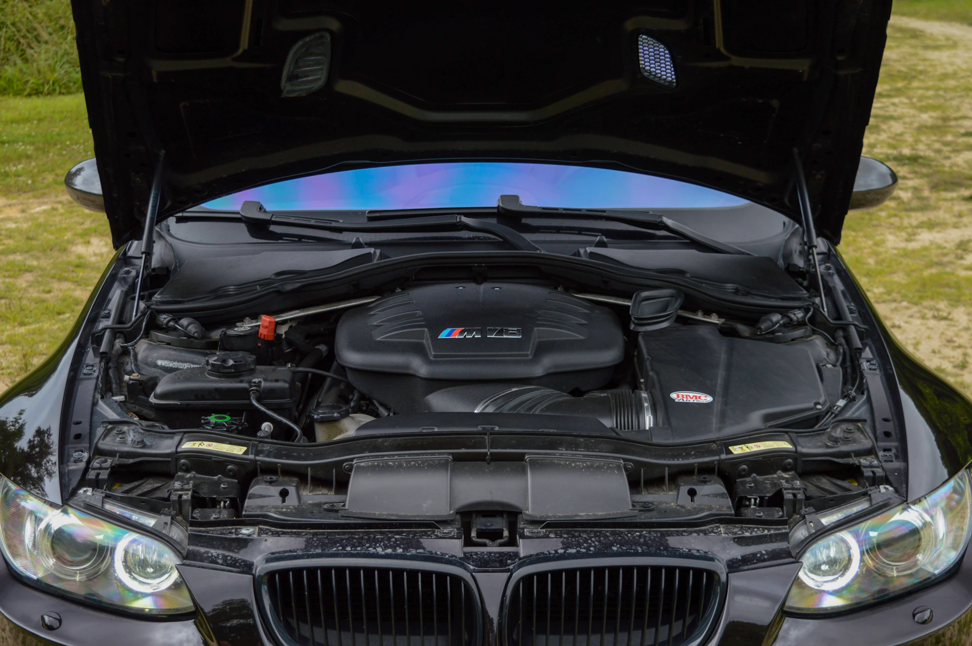the engine of a car is open on the grass