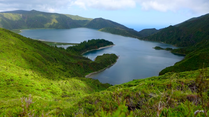 a large body of water surrounded by lush green hills