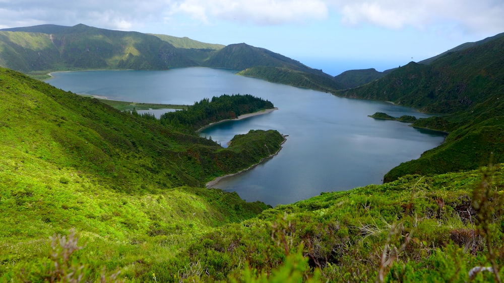 a large body of water surrounded by lush green hills