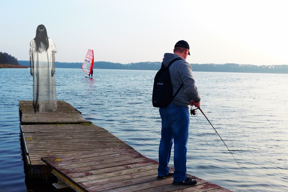 a man standing on a dock holding a fishing rod