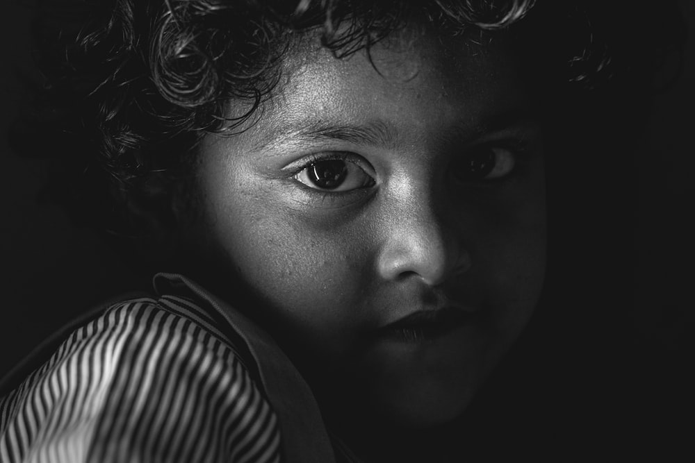 a black and white photo of a child with curly hair