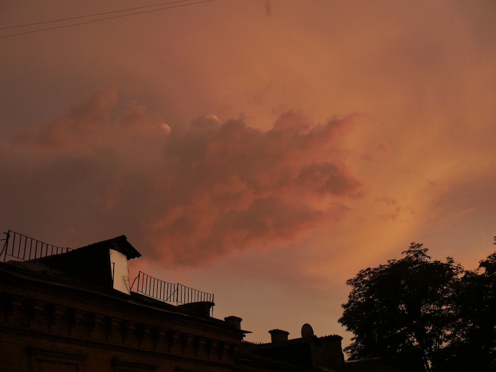 a pink cloud is in the sky above a building