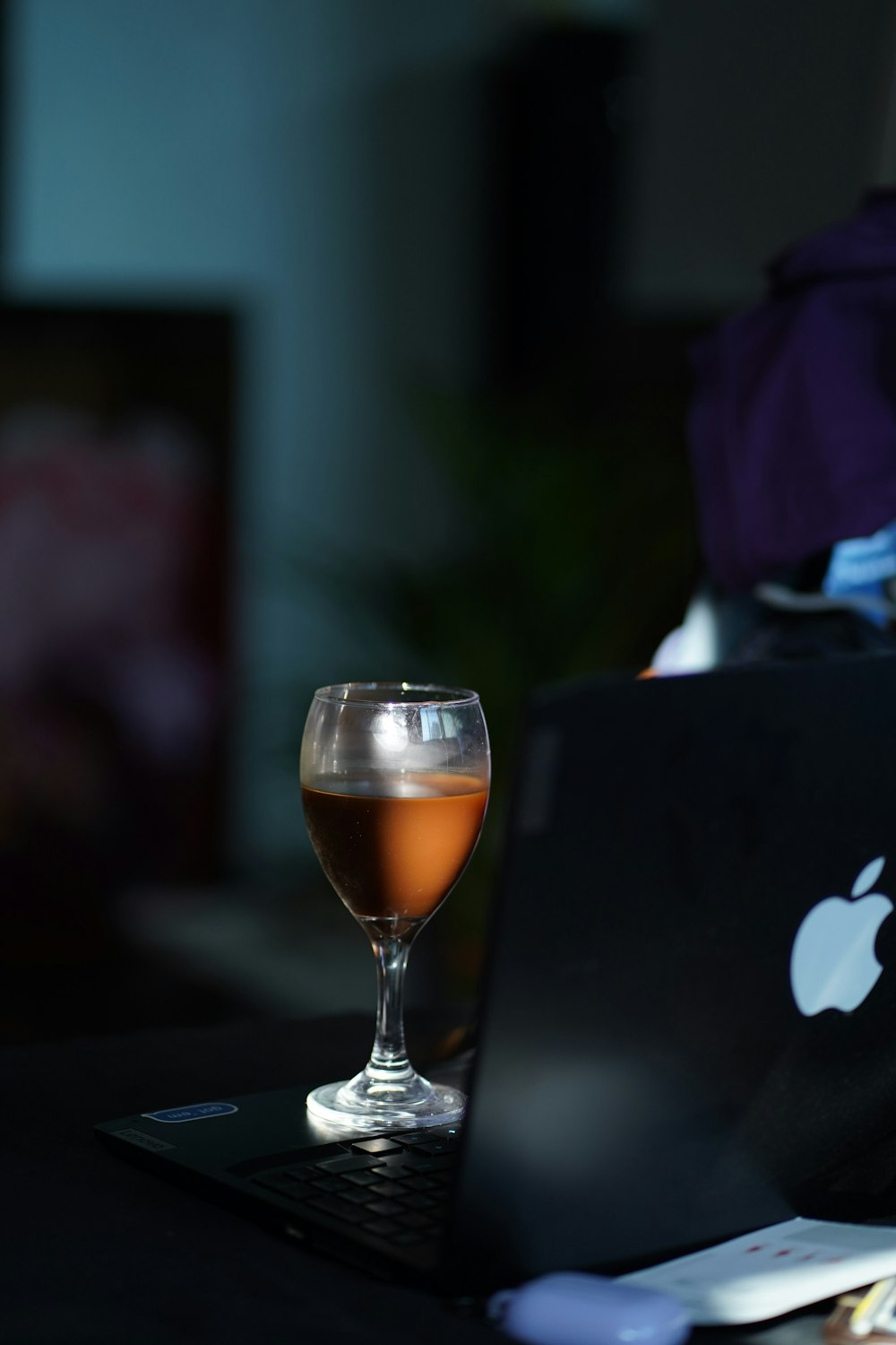 a glass of wine sitting on top of a laptop computer