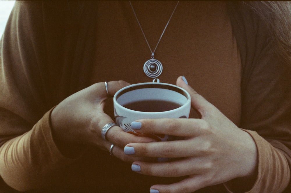 コーヒーカップを手に持つ女性