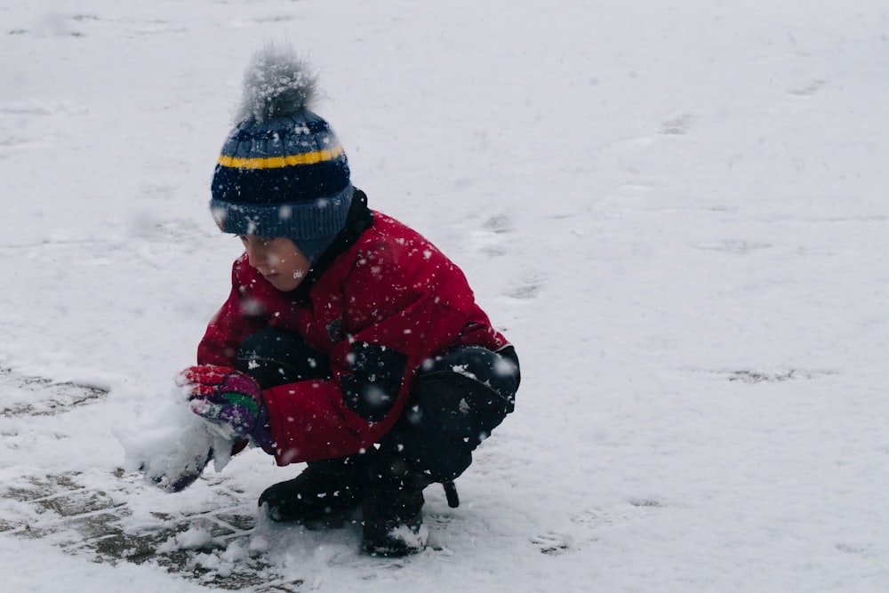 Un ragazzo che gioca nella neve con un frisbee