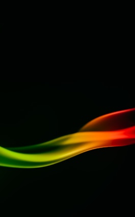 A smooth, abstract wave of colors flows against a dark background, transitioning from vibrant red to orange, yellow, and finally green. The colors blend seamlessly, creating a dynamic and fluid motion effect.