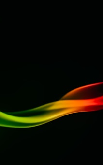 A smooth, abstract wave of colors flows against a dark background, transitioning from vibrant red to orange, yellow, and finally green. The colors blend seamlessly, creating a dynamic and fluid motion effect.