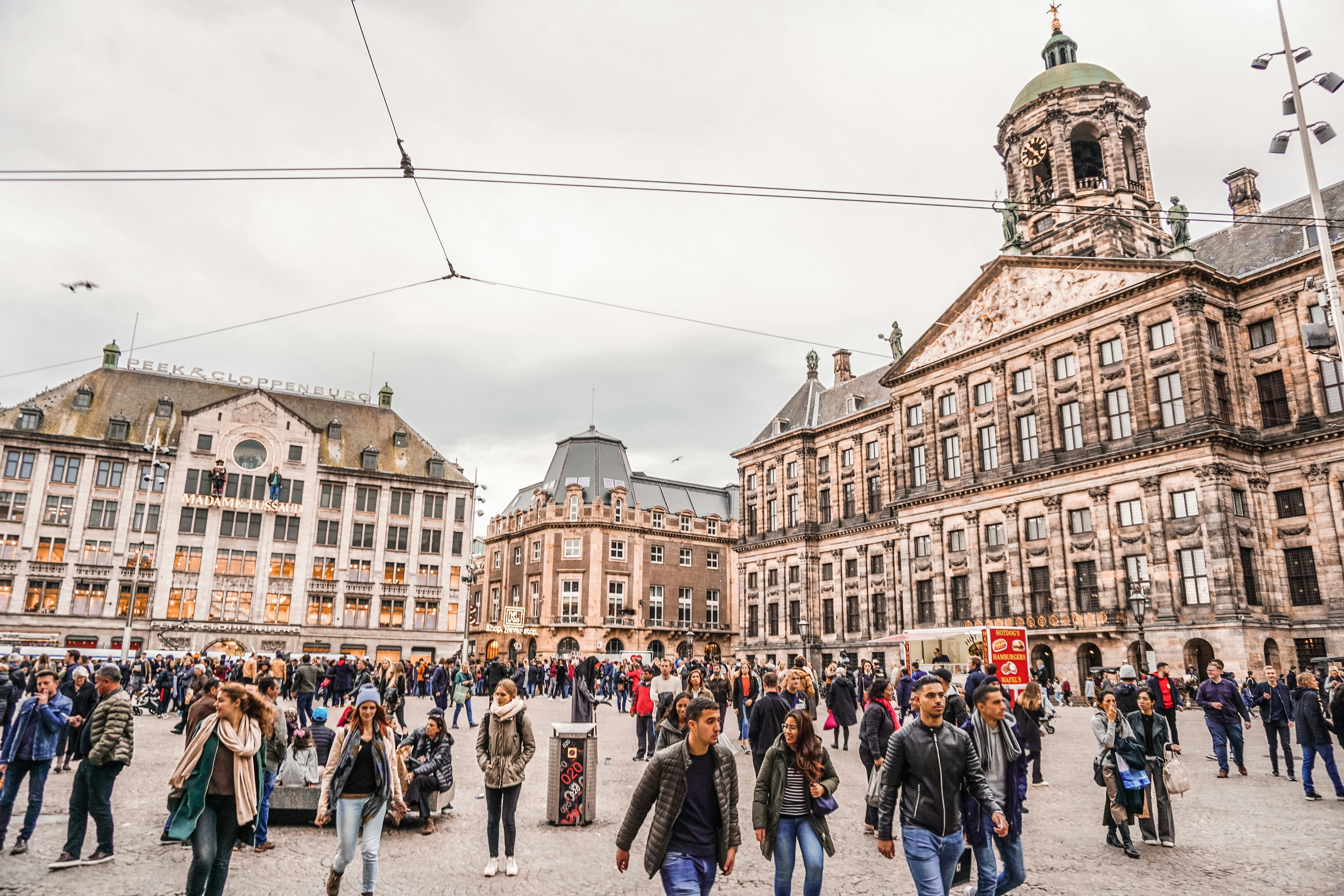 a crowd of people walking around a city square