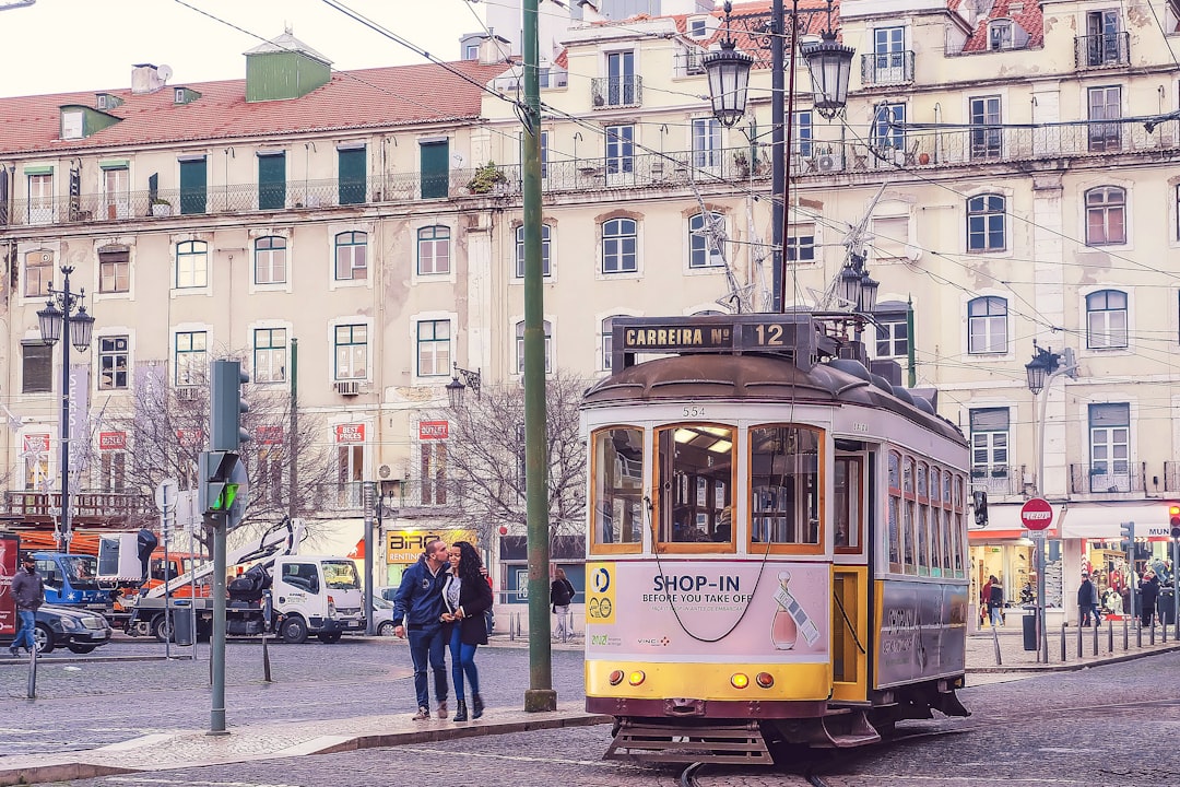 a couple of people standing on a street next to a trolley,
