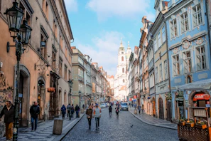 Historic cobblestone streets of Prague with people strolling and chatting.