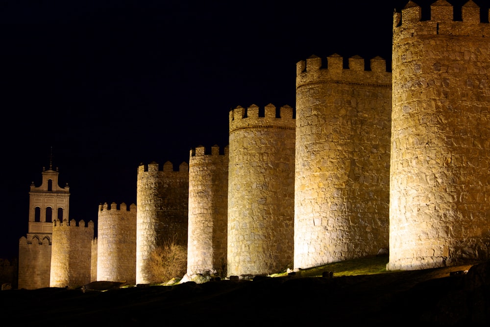 Una hilera de estructuras parecidas a castillos iluminados por la noche