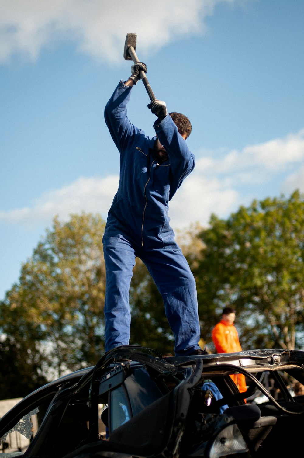 a man holding a hammer up to a car