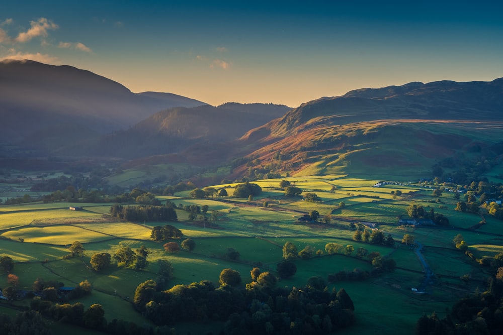 an aerial view of a valley with mountains in the background