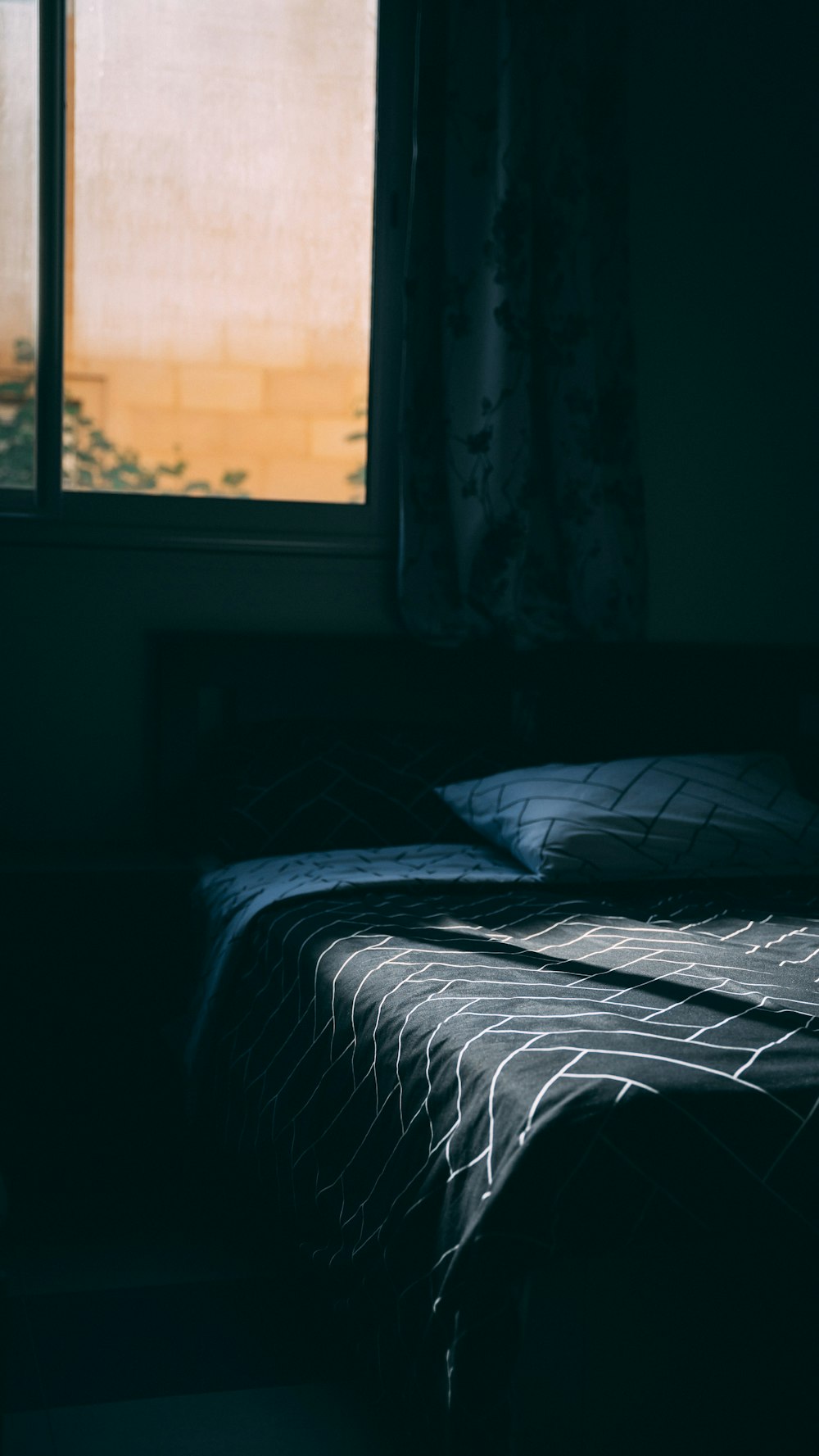 a bed sitting in a bedroom next to a window