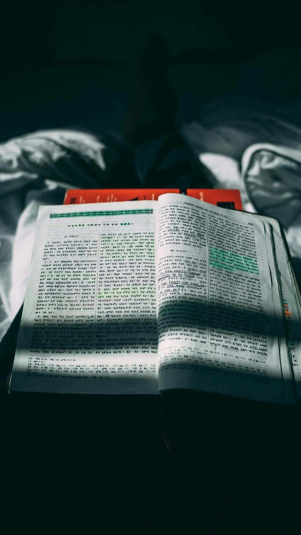 an open book sitting on top of a bed