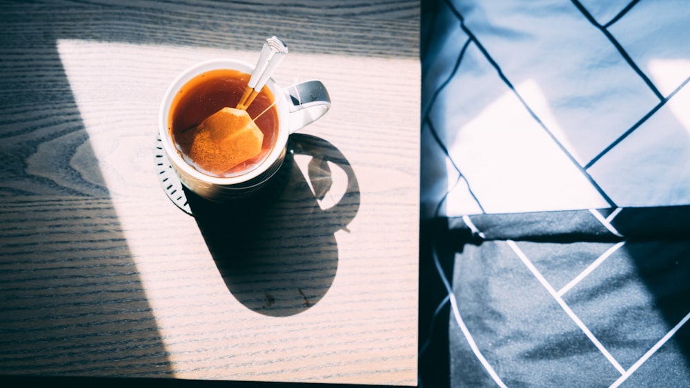 a cup of tea and a spoon on a table